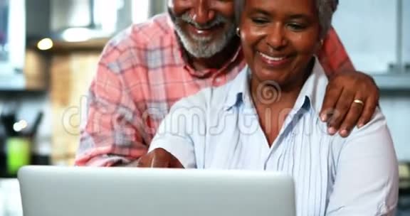 在厨房里用笔记本电脑的老夫妇视频的预览图