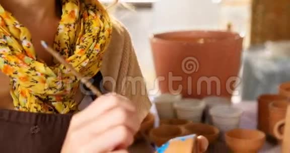 漂亮的女陶工在碗上画画视频的预览图