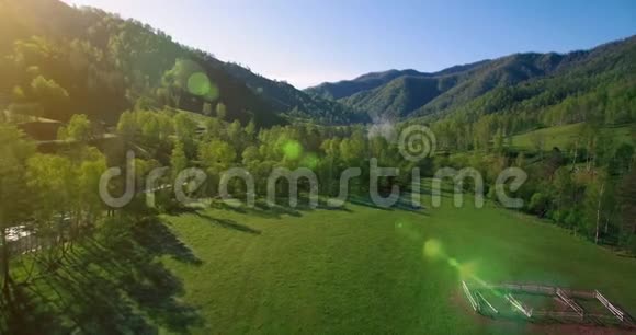 在阳光明媚的夏日早晨中气飞越新鲜的山河和草地农村土路下面视频的预览图