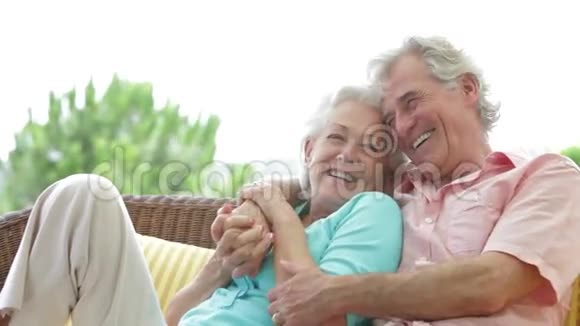年长夫妇一起坐在户外座位上视频的预览图