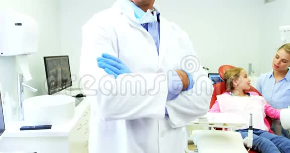 微笑牙医站在牙科诊所交叉双臂视频的预览图