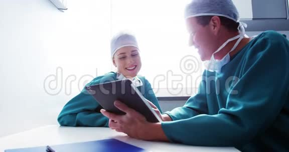 医生和同事讨论数字平板电脑视频的预览图
