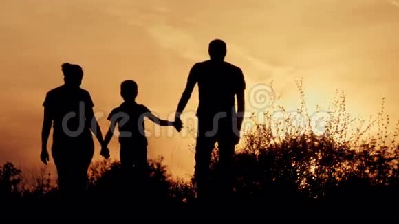 剪影和父母在一起的幸福孩子日落时分的家人视频的预览图