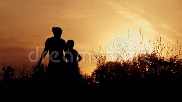 剪影和父母在一起的幸福孩子日落时分的家人视频的预览图