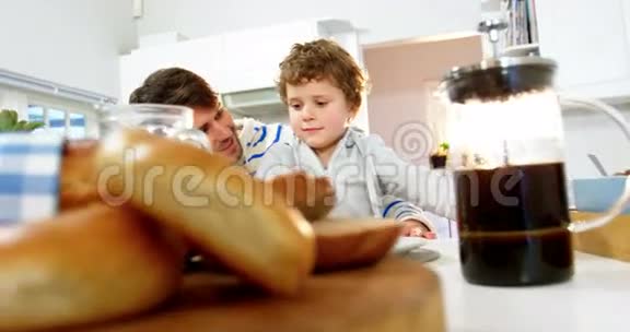 父子俩在厨房吃早餐视频的预览图