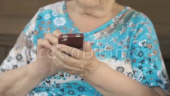 老年妇女拿着智能手机视频的预览图