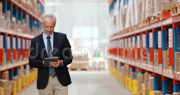 男性仓库经理使用数字平板电脑视频的预览图