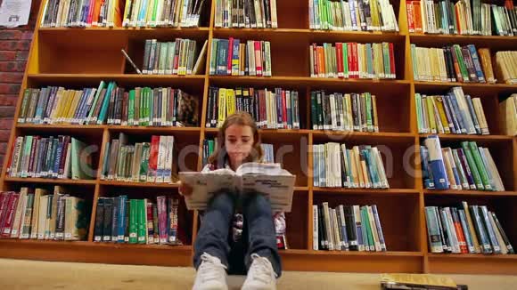 坐在图书馆地板上看书的漂亮学生视频的预览图