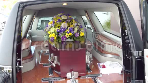 在葬礼或墓地埋葬前在灵车上的一个彩色棺材视频的预览图