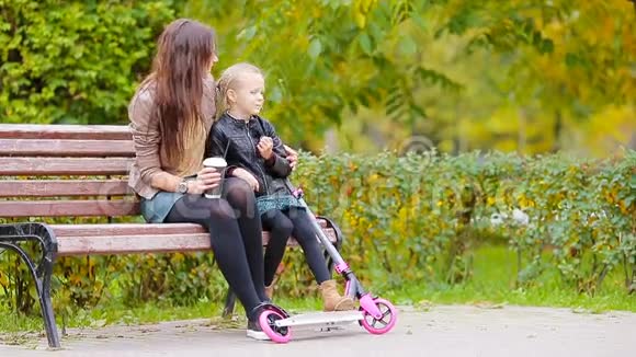 可爱的小女孩和妈妈一起享受秋天的户外公园视频的预览图