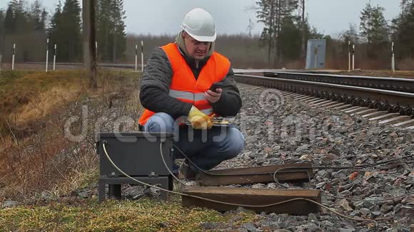 铁路员工在铁路附近使用手机视频的预览图