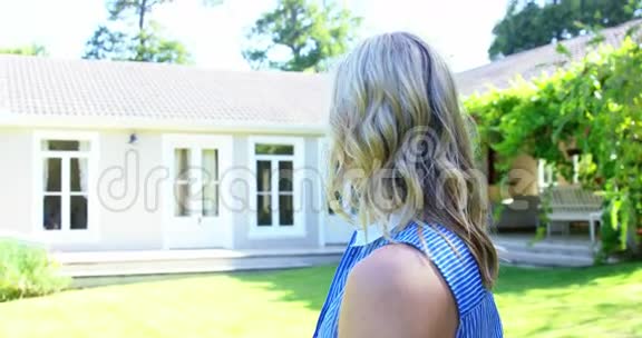 女人在房子前微笑的肖像视频的预览图