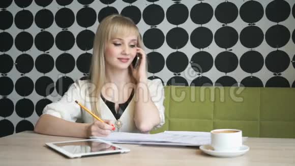 坐在咖啡馆里用手机说话的女孩视频的预览图