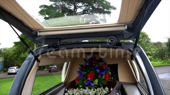 在葬礼或墓地埋葬前在灵车上的一个彩色棺材视频的预览图