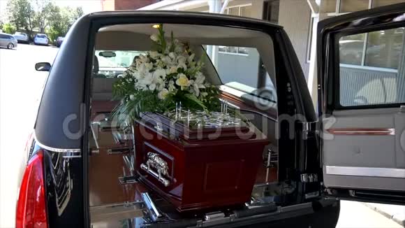 墓地葬礼或葬礼前在灵车或礼拜堂拍摄的彩色棺材特写镜头视频的预览图