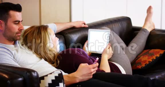 沙发上用手机和数码平板电脑的情侣视频的预览图