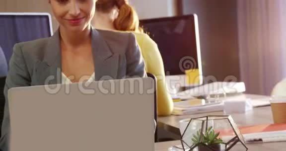 女商人在桌子上用笔记本电脑工作视频的预览图