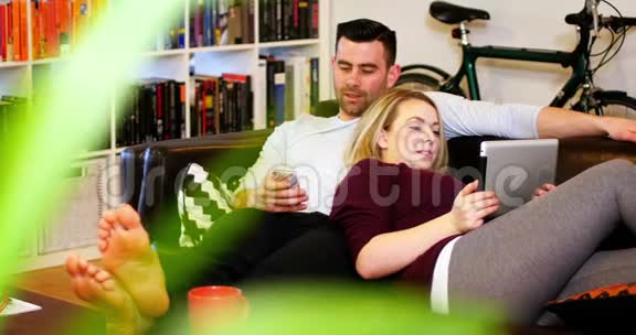 沙发上用手机和数码平板电脑的情侣视频的预览图