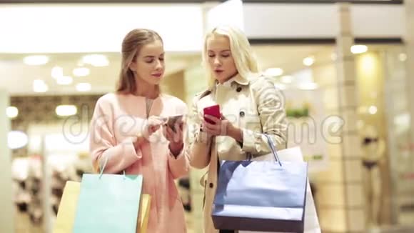 带着智能手机和购物袋的快乐女人视频的预览图