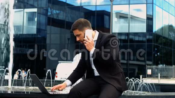 商务人士在打电话时使用笔记本电脑视频的预览图
