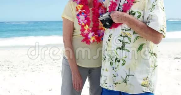 在海滩上微笑的老夫妇视频的预览图