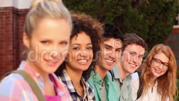 坐在一排对着镜头微笑的快乐学生视频的预览图