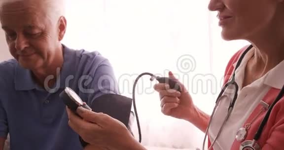 女医生检查一位年长男子的血压视频的预览图