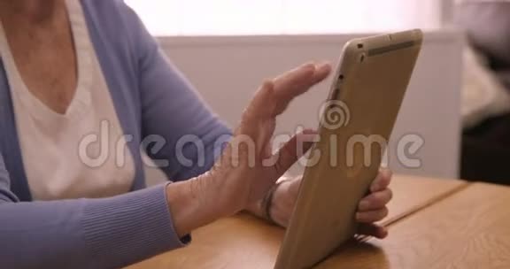 微笑高级妇女使用数字平板电脑视频的预览图