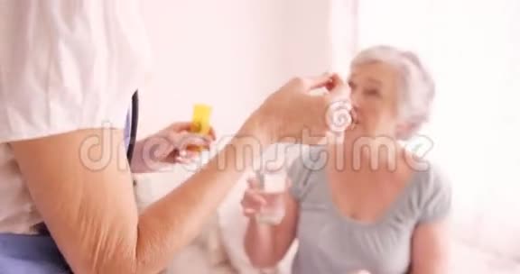 给老年妇女吃药的女医生视频的预览图