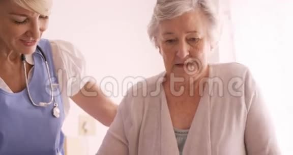 协助一名老年妇女走路的女医生视频的预览图