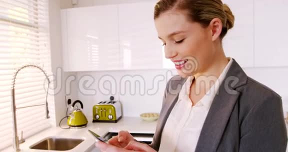 女人在厨房里用手机视频的预览图