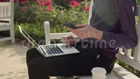 公园里的年轻人用笔记本电脑和电话视频的预览图