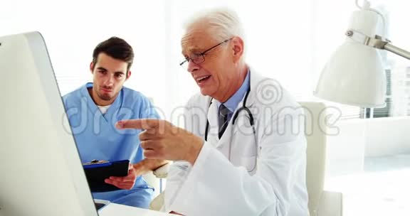 男医生和同事在电脑上讨论视频的预览图