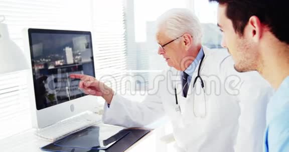 男医生和同事在电脑上讨论视频的预览图