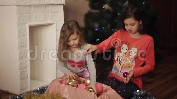 两个妹妹用杉木装饰圣诞树新年准备快乐的女孩和家人视频的预览图
