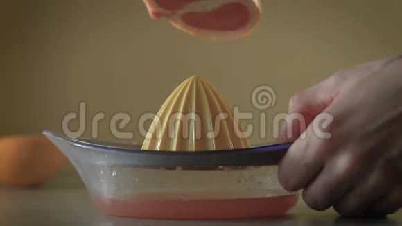 厨房里用手捏着新鲜的葡萄柚汁视频的预览图