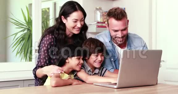 微笑的家人使用笔记本电脑视频的预览图
