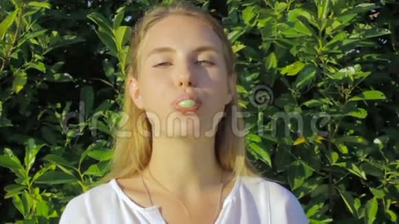 可爱的年轻女孩在户外嚼口香糖视频的预览图