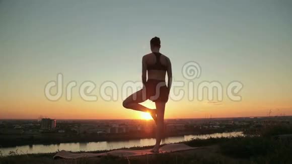 日落时分在公园练习瑜伽的女人视频的预览图