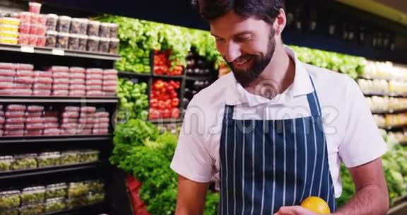 在超市有机区叼水果的男员工微笑视频的预览图