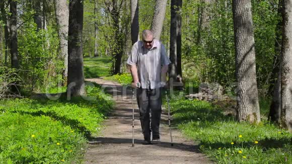 拄拐的残疾人在公园散步视频的预览图