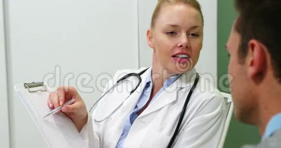 微笑女医生在剪贴板上解释病人视频的预览图