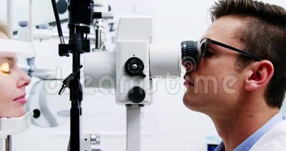 视光师在裂隙灯上检查女性病人视频的预览图