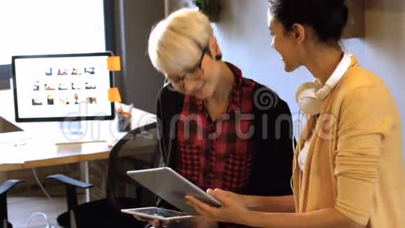 两位女商务主管在数码平板电脑上互动视频的预览图