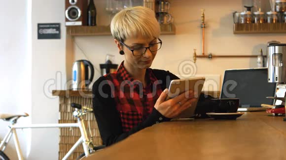 女商务主管在喝咖啡时使用数码平板电脑视频的预览图