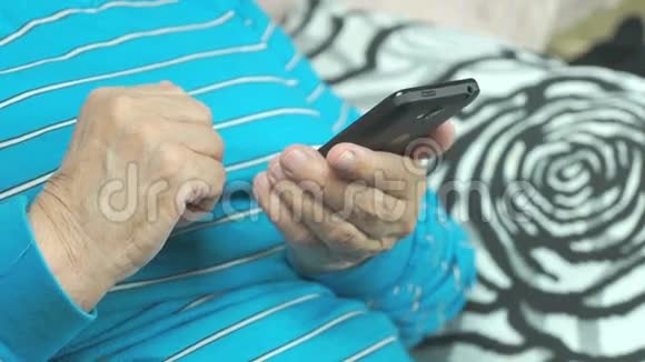 老妇人的手和智能手机视频的预览图