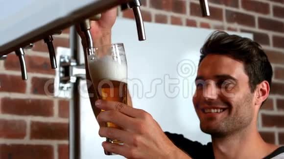微笑的酒吧老板拉着一品脱啤酒视频的预览图