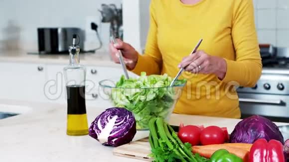 高级妇女准备蔬菜沙拉视频的预览图