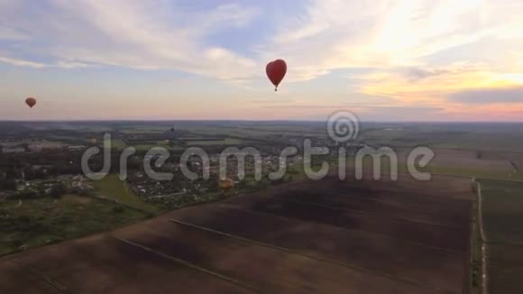 热气球在天空中飞过田野空中景观视频的预览图
