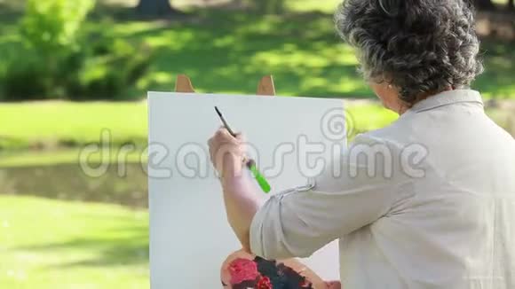 幸福成熟的女人在画布上画画视频的预览图